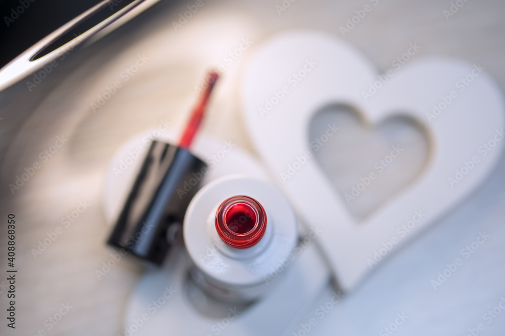 Beautiful red varnish in a bottle in a nail salon for nail design for Valentine's Day. Beautiful red varnish in a bottle in a nail salon for nail design for Valentine's Day.