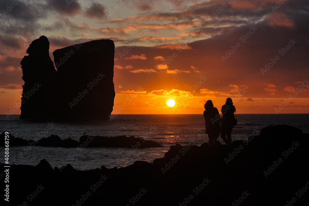 Silhouette of two people, during sunset, in Mosteiros, Sao Miguel island, Azores.