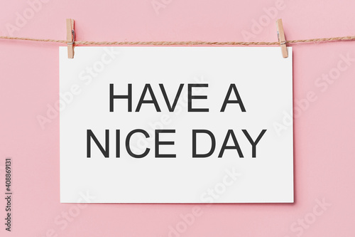note letter pin on rope on pink background, love and valentine concept with text HAVE A NICE DAY