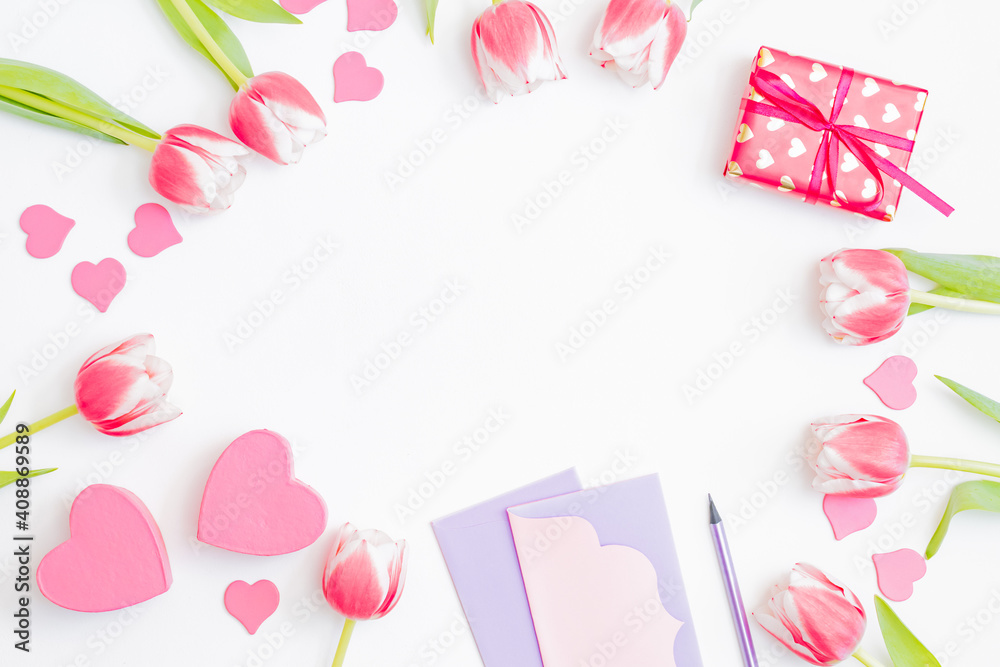 Flat lay valentines day frame with pink tulips and gift box on a white background