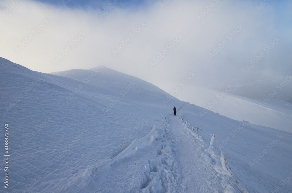 hiker on the mountain trail in winter