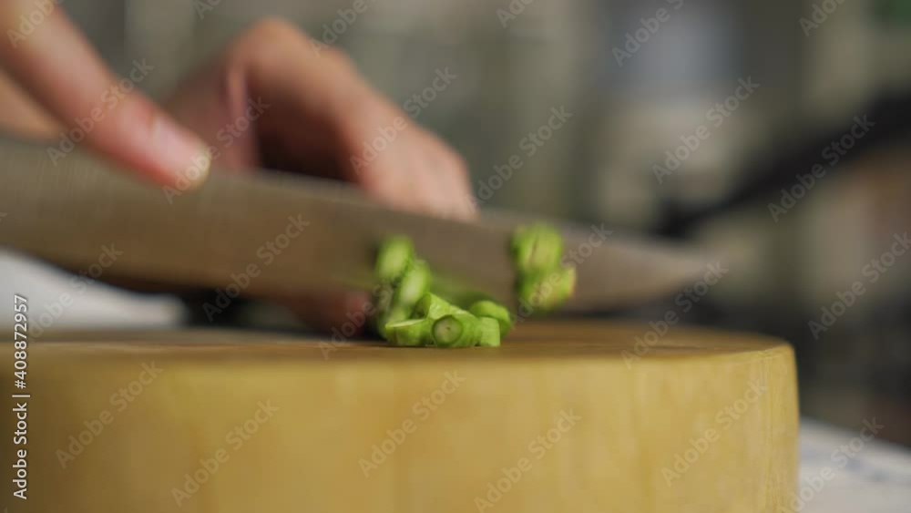 People cutting Yard long beans on wooden cutting board for cooking meals, Prepare process, Asian's homegrown vegetable, kitchen background, side view, close up, defocus People cutting Yard long beans on wooden cutting board for cooking meals, Prepare process, Asian's homegrown vegetable, kitchen background, side view, close up, defocus