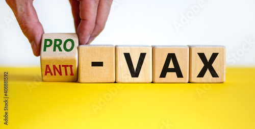 Pro-vax or anti-vax symbol. Doctor turns a cube, changes words 'anti-vax' to 'pro-vax'. Beautiful yellow table, white background. Copy space. Business, medical covid-19 pro-vax or anti-vax concept.