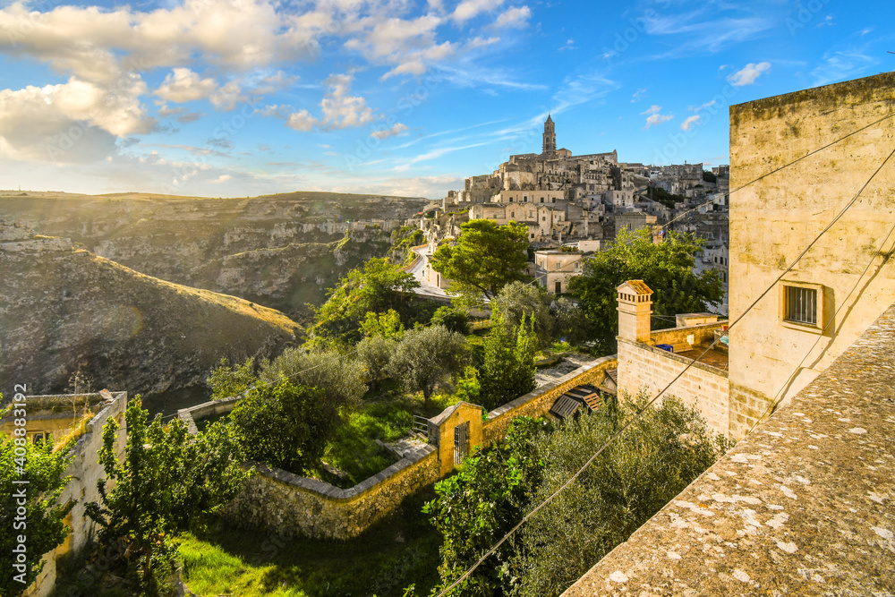 View of the ancient city of Matera, Italy in the Basilicata region, including the old town, tourist street and mountain path, Sasso Barisano tower and the steep ravine canyon below