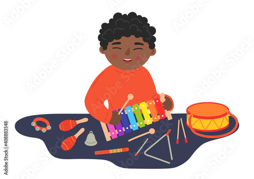 African ethnicity boy playing xylophone on the table. Kids' wooden musical instruments. Children musical and creativity development concept. 