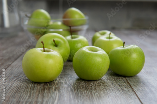 green apples on a wooden table in plate
