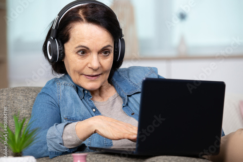 beautiful concentrated middle aged woman on generic laptop computer