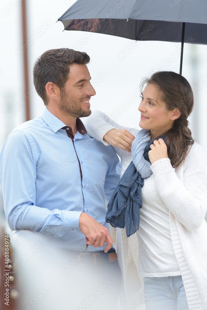 romantic couple sheltering under umbrella romantic couple sheltering under umbrella