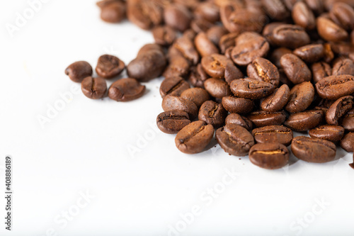 Pile of coffee beans on a white surface. Background and texture. 