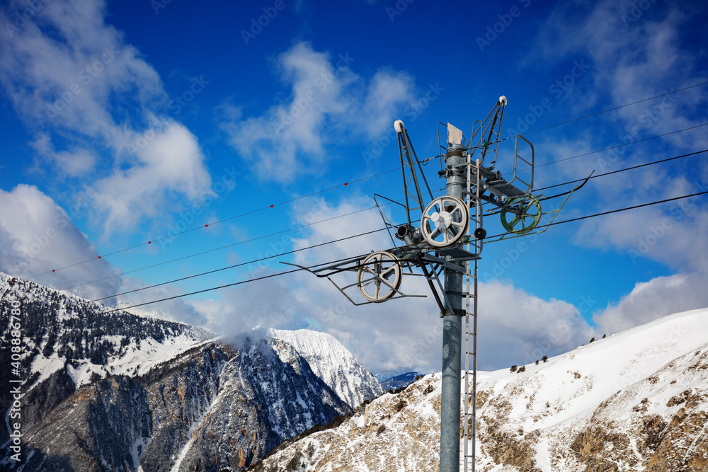Ski lift details over blue sky and mountain peaks in French Alps Ski lift details over blue sky and mountain peaks in French Alps