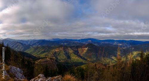 soft green mountains in the sun and grey sky panorama © thomaseder