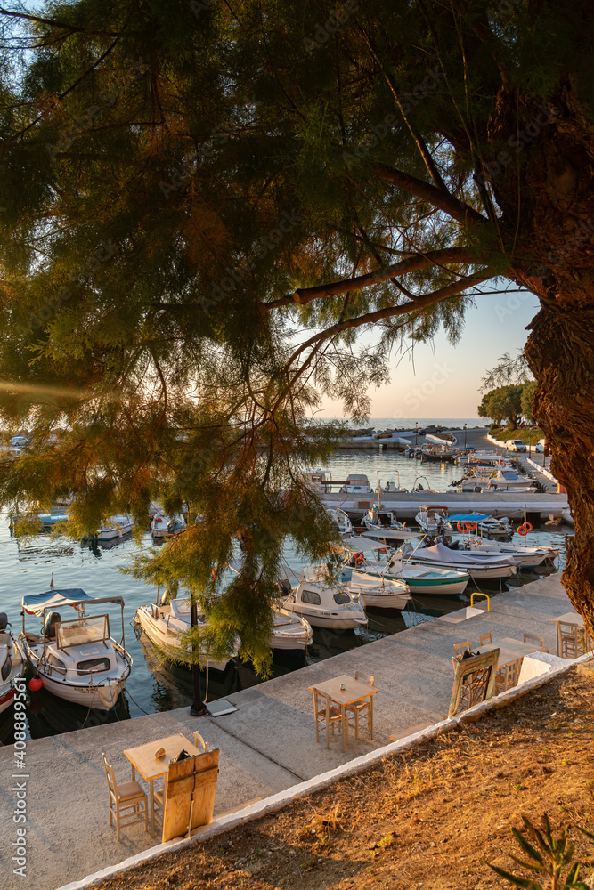 Nea Hora marina beach in Chania, Crete, Greece. Traditional greek tavern by the sea. Boats anchoring at the marina. Romantic sunset, warm colors. Nea Hora marina beach in Chania, Crete, Greece. Traditional greek tavern by the sea. Boats anchoring at the marina. Romantic sunset, warm colors.