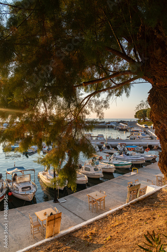 Nea Hora marina beach in Chania  Crete  Greece. Traditional greek tavern by the sea. Boats anchoring at the marina. Romantic sunset  warm colors.