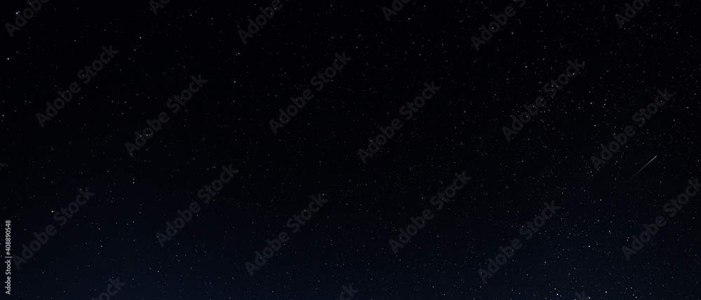 Fototapeta premium A starry sky with many stars and a flying meteor