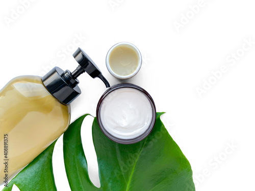 Beautiful composition with cosmetics on white background with tropical leaf, flat lay.