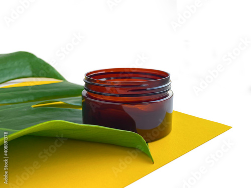 Beautiful composition with cosmetics on white background with tropical leaf.