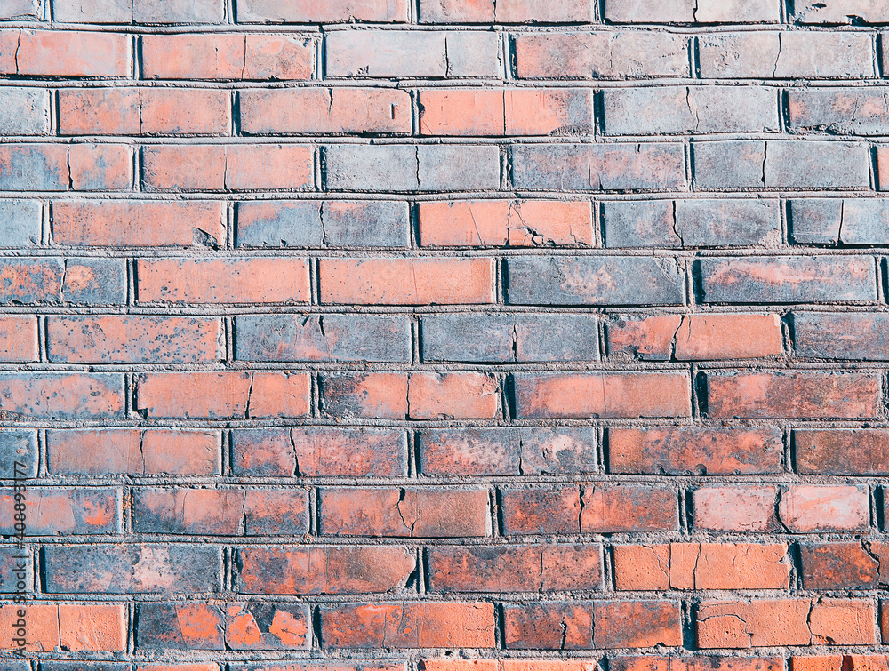 Obraz premium The wall, made of old red bricks, darkened by old age. Ancient vintage brick wall background. Brick wall backdrop