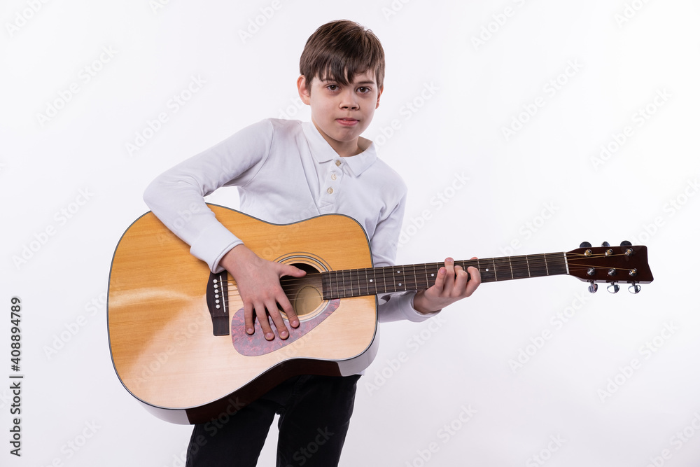 Obraz premium Photo of a young teenager playing a guitar and lookimg at the camera
