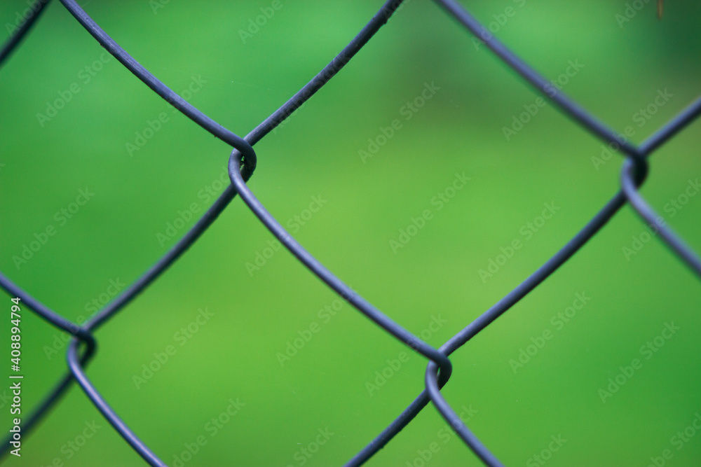 Naklejka premium metallic fence with fresh grass on the background