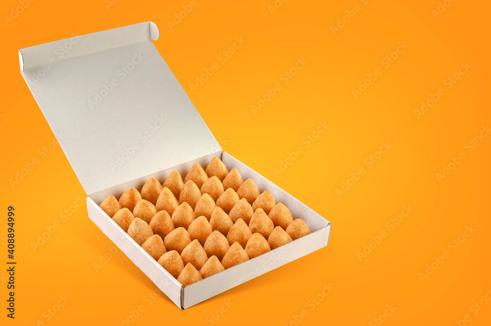 A box of deep fried croquettes for delivery isolated in orange background (coxinha de frango) A box of deep fried croquettes for delivery isolated in orange background (coxinha de frango)