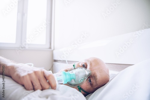 Sick patient man breathing with oxygen mask in hospital