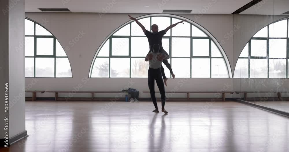Male dancer lifting partner up while dancing in studio Male dancer lifting partner up while dancing in studio