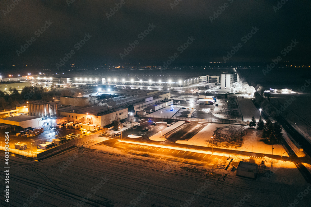 Aerial view of the trucks unloading at the logistic center. Night view with a bit of snow.