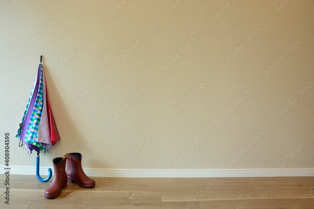 Obraz premium women's colorful umbrella and rain boot on floor.blurred background with copy space.
