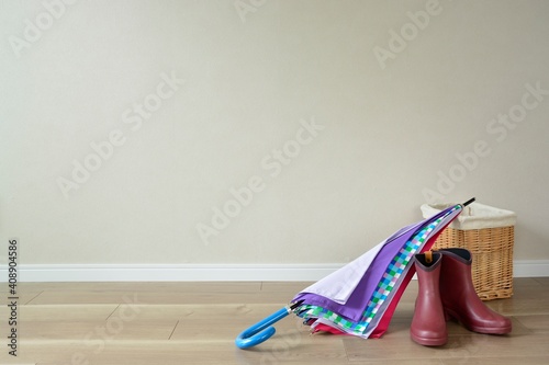 women's colorful umbrella and rain boot on floor.   blurred background with copy space. © NaoakiMiyamoto
