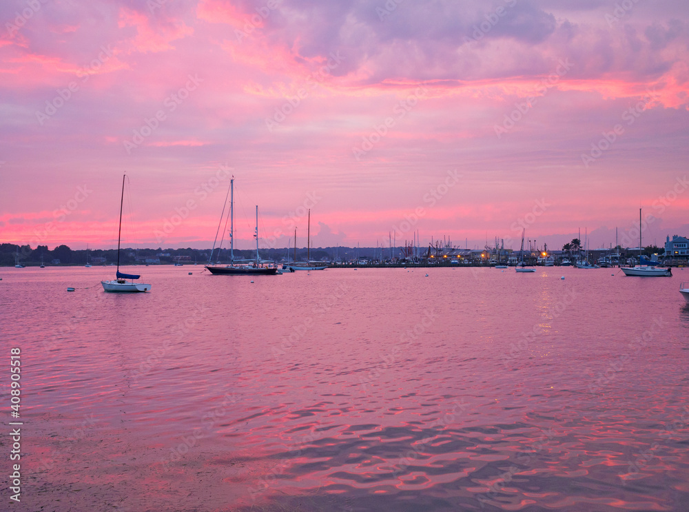 Summer sailboats in Stonington harbor dramatic pink and purple sunset. Stonington is the only Connecticut harbor on the Atlantic Ocean.