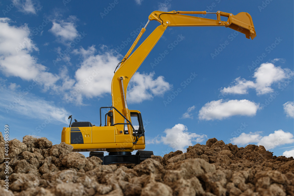 Yellow excavators are digging the soil in the construction site on the cloud and sky background Yellow excavators are digging the soil in the construction site on the cloud and sky background