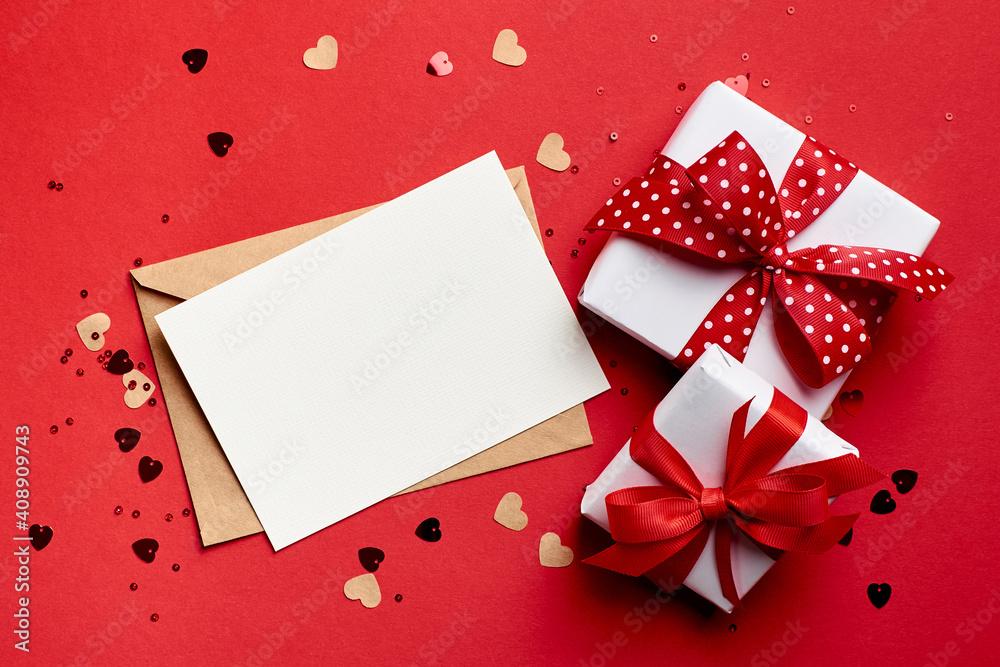Valentines day card mockup with gift boxes and small hearts on red paper background Valentines day card mockup with gift boxes and small hearts on red paper background