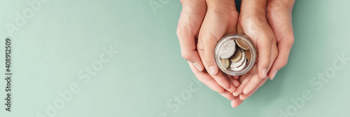 child and parent hands holding money jar,fundraising charity, donation, saving, family finance plan concept