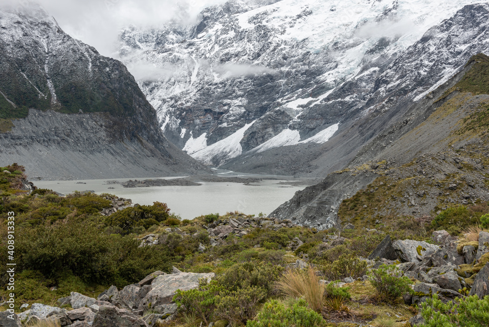Mueller Lake in Aoraki/Mount Cook National Park, New Zealand, surrounded by mountains and huge piles of moraine.