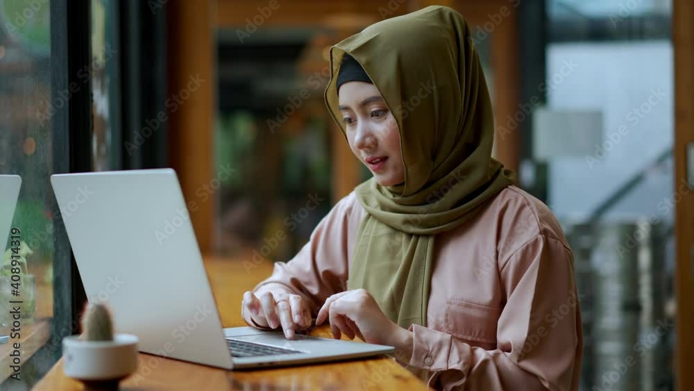 Young muslim woman working with laptop in coffee shop Young muslim woman working with laptop in coffee shop