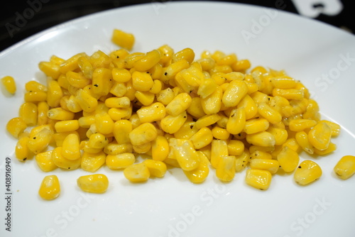 Yellow Corn Niblets on a White Plate Background photo