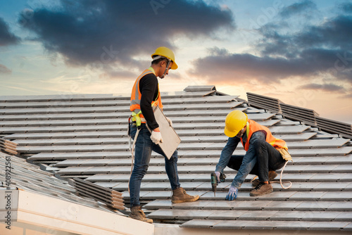 Canvas Print Asian engineer workers install new CPAC roof, roofing tools, electric drill, use on new roof with CPAC roof house construction idea