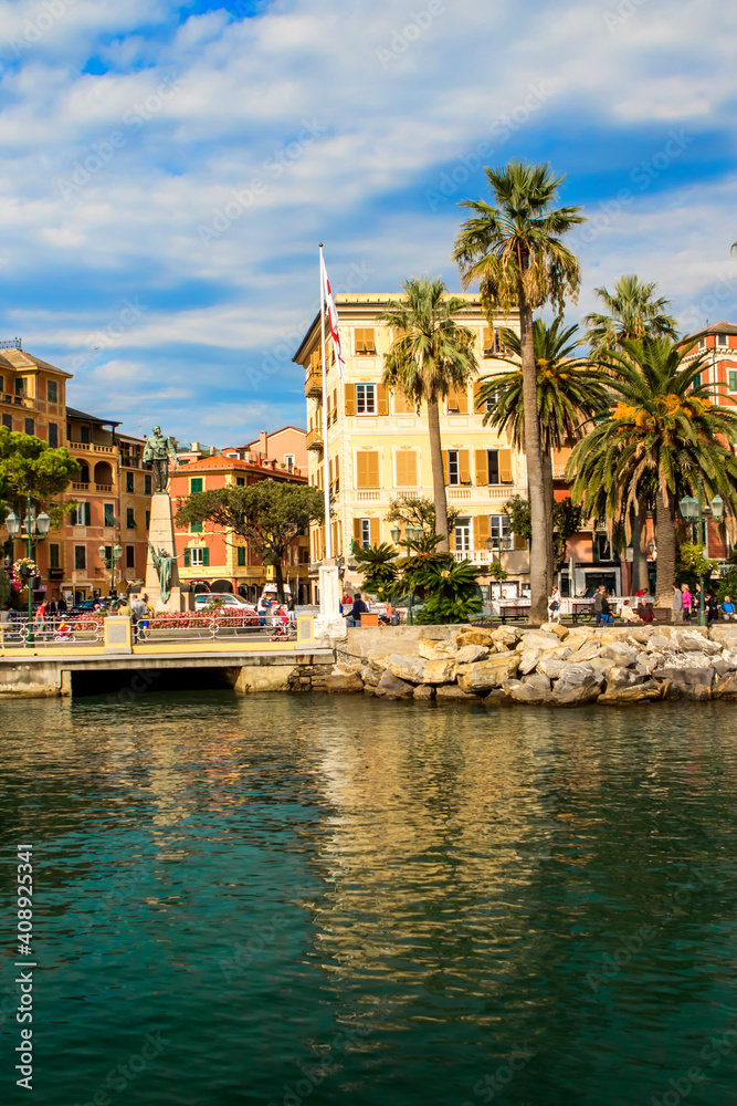 Italy. A picturesque town on the Ligurian coast. Colorful colorful Mediterranean houses on the coastline of a stone beach among green trees. A popular resort and tourist destination.