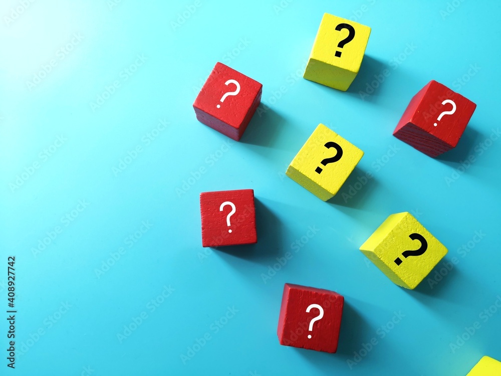Obraz premium red and yellow cubes with question symbol over blue background