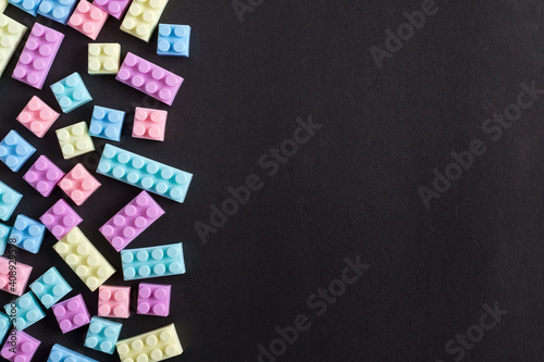Toy building blocks on black background with empty space on one side