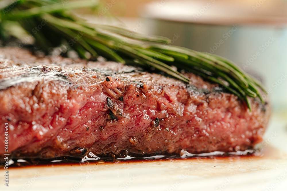 Closeup on roasted beef medium rare steak with a rosemary Closeup on roasted beef medium rare steak with a rosemary