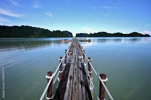 Fisherman's wooden bridge and small fishing boats set out to sea in the morning