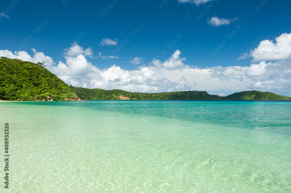 Perfect tropical beach, crystalline emerald green sea, green mountains, blue sky. Iriomote Island.