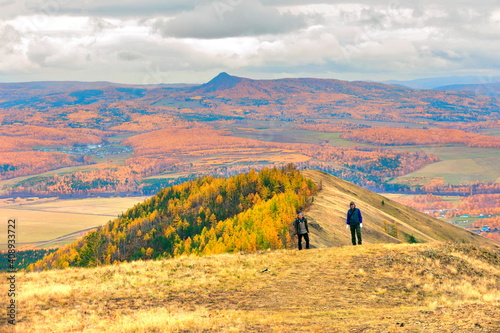 mature male tourists walk along the ridge of the big krak on an autumn day.
