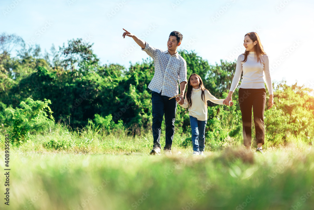 Girl with mother and father holding hands on the nature. Child with parents outdoors Girl with mother and father holding hands on the nature. Child with parents outdoors