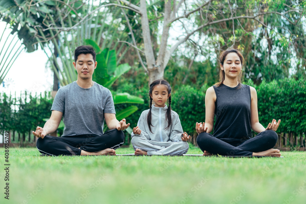 Asian Family Practicing Yoga in park at their home Asian Family Practicing Yoga in park at their home