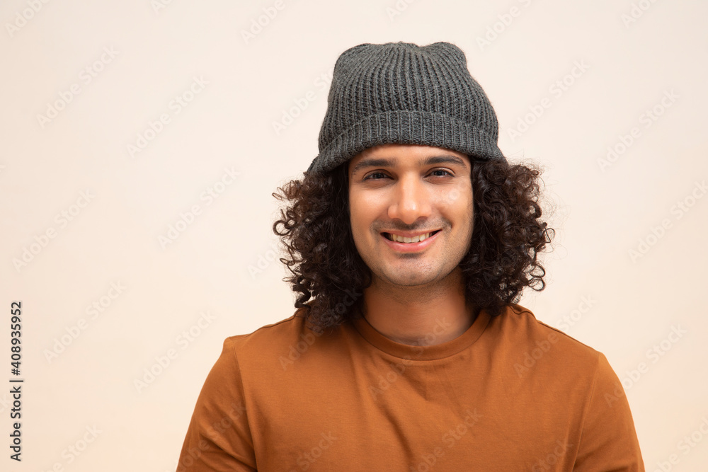 PORTRAIT OF A CURLY HAIRED MAN WEARING CAP AND SMILING AT CAMERA PORTRAIT OF A CURLY HAIRED MAN WEARING CAP AND SMILING AT CAMERA