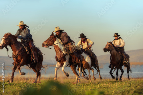 Fotobehang Cowboy riding a horse carrying a gun