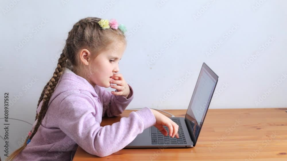 The child learns while sitting at the laptop. Homeschooling concept, online school The child learns while sitting at the laptop. Homeschooling concept, online school