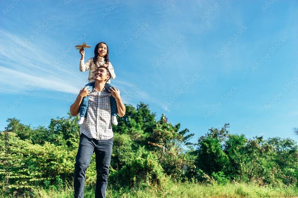 Daughter sits on his father's neck.The family enjoyed a holiday Holiday over beautiful nature.Concept People and family.